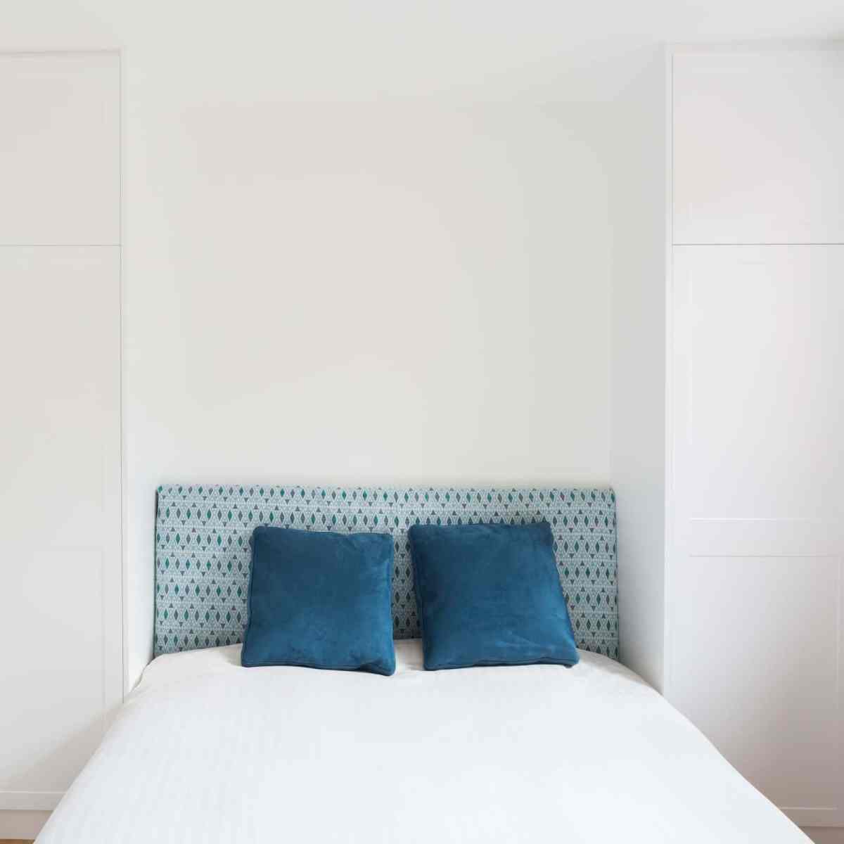 Penderie en laqué blanc mat pour aménager la tête de lit de cette chambre réalisée sur mesure - 2850€ TTC