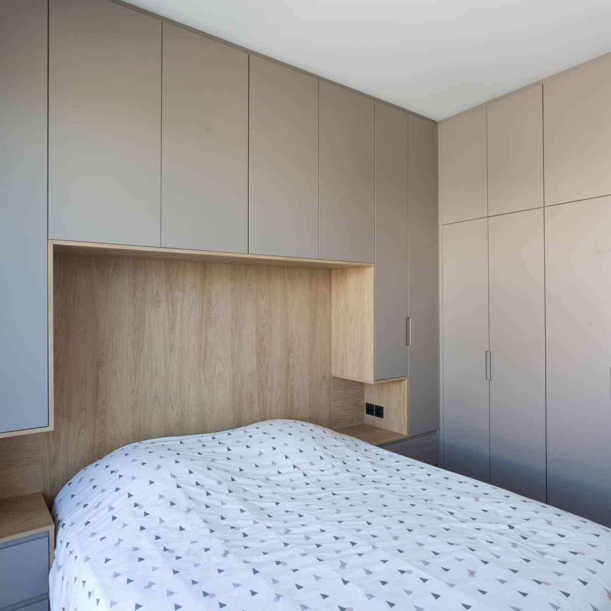 Cette tête de lit sur mesure est intégrée dans la pièce en angle, apportant ainsi 2 espaces chevets et de nombreuses penderies sur mesure